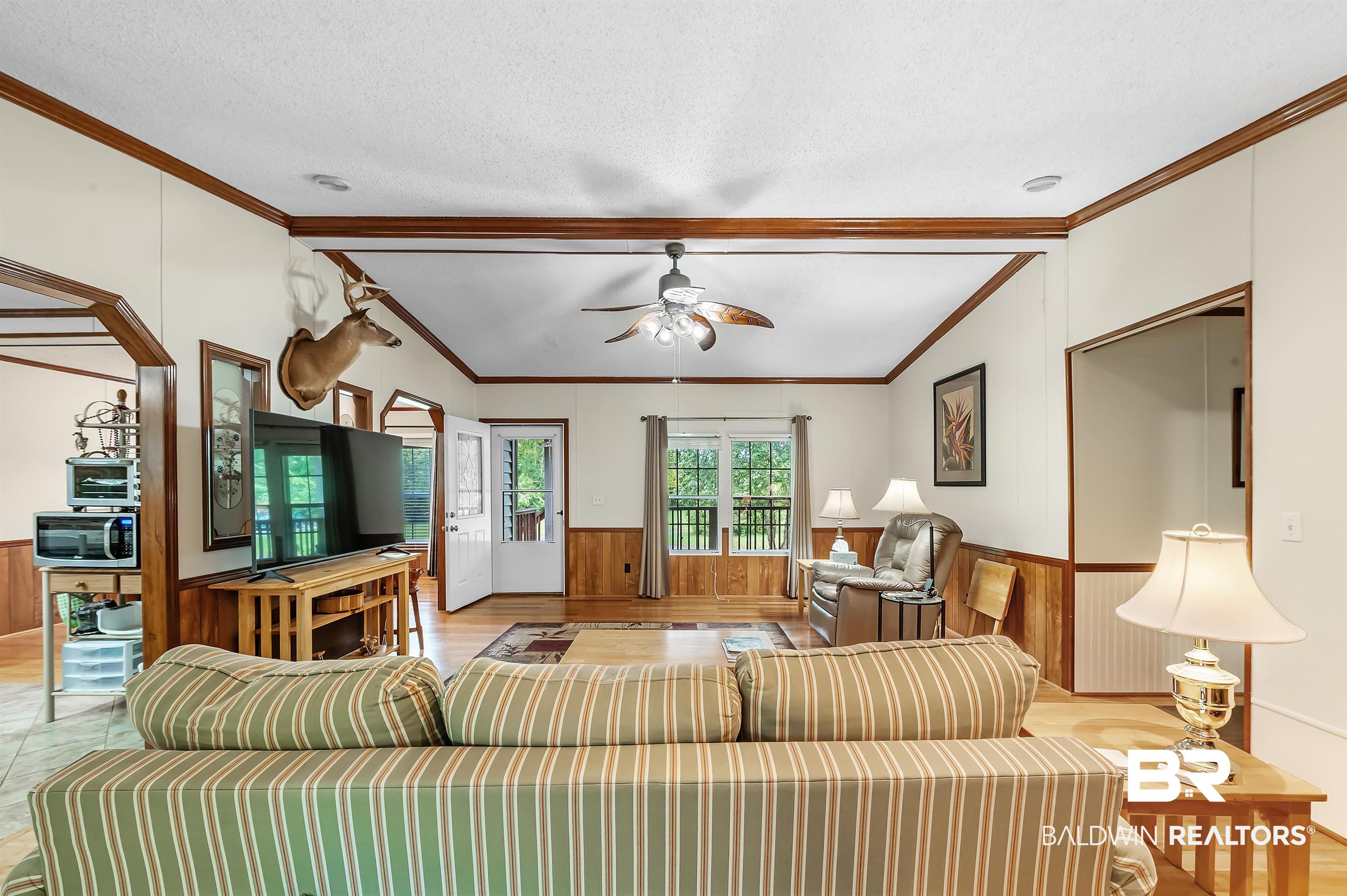 10970 Stucki Road Elberta, AL 36530 - Photo 14 of 56 Living room with light Bamboo floors, a textured ceiling, lofted ceiling with beams, and ceiling fan
