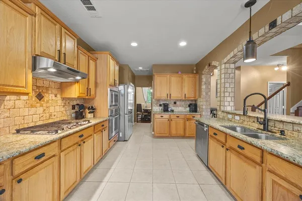 a large kitchen with stainless steel appliances lots of counter space and a sink