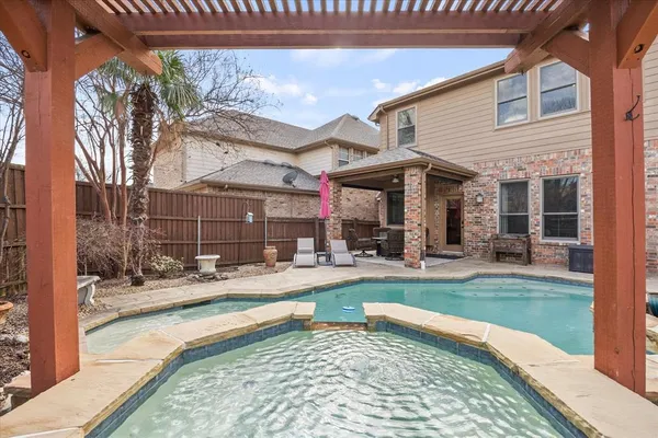 a view of a swimming pool with sitting area and furniture