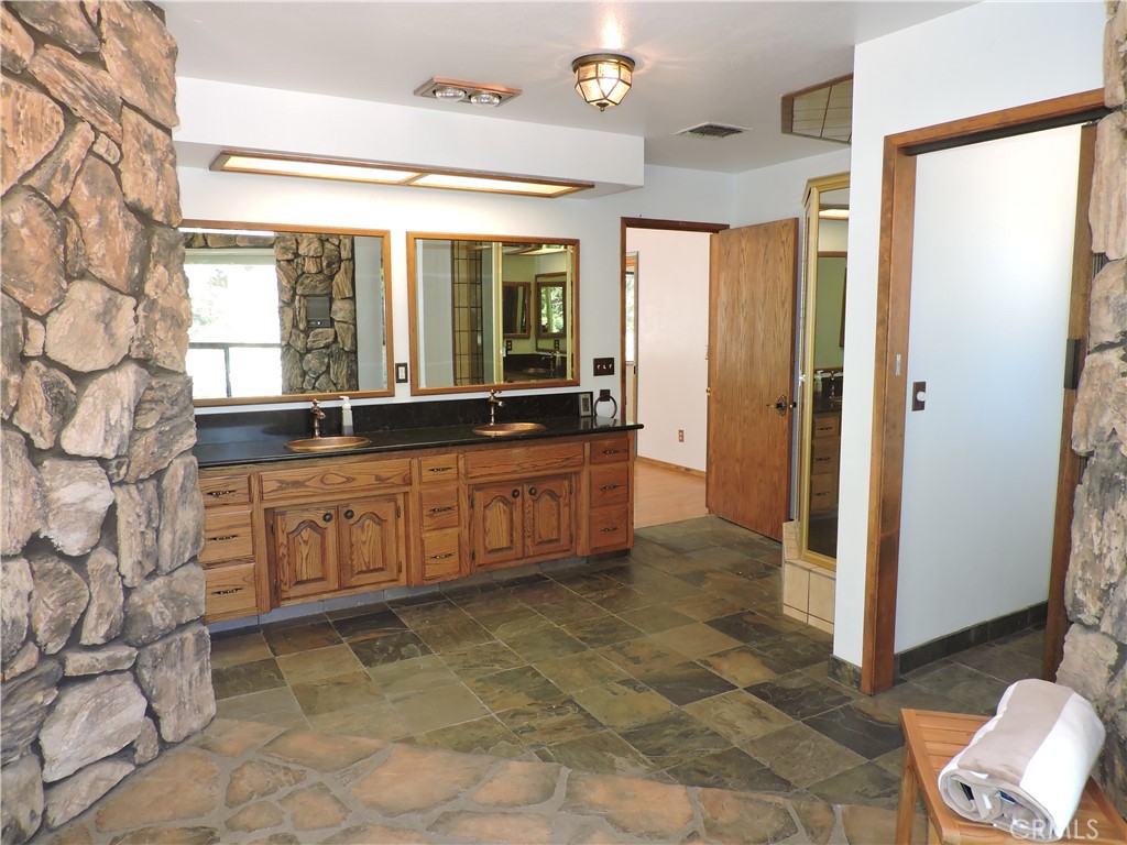26931 Columbia Way Tehachapi, CA 93561 - Photo 46 of 49 Primary Bathroom with Large Vanity with Copper sinks and Fixtures, stone tile flooring and Stall Shower.