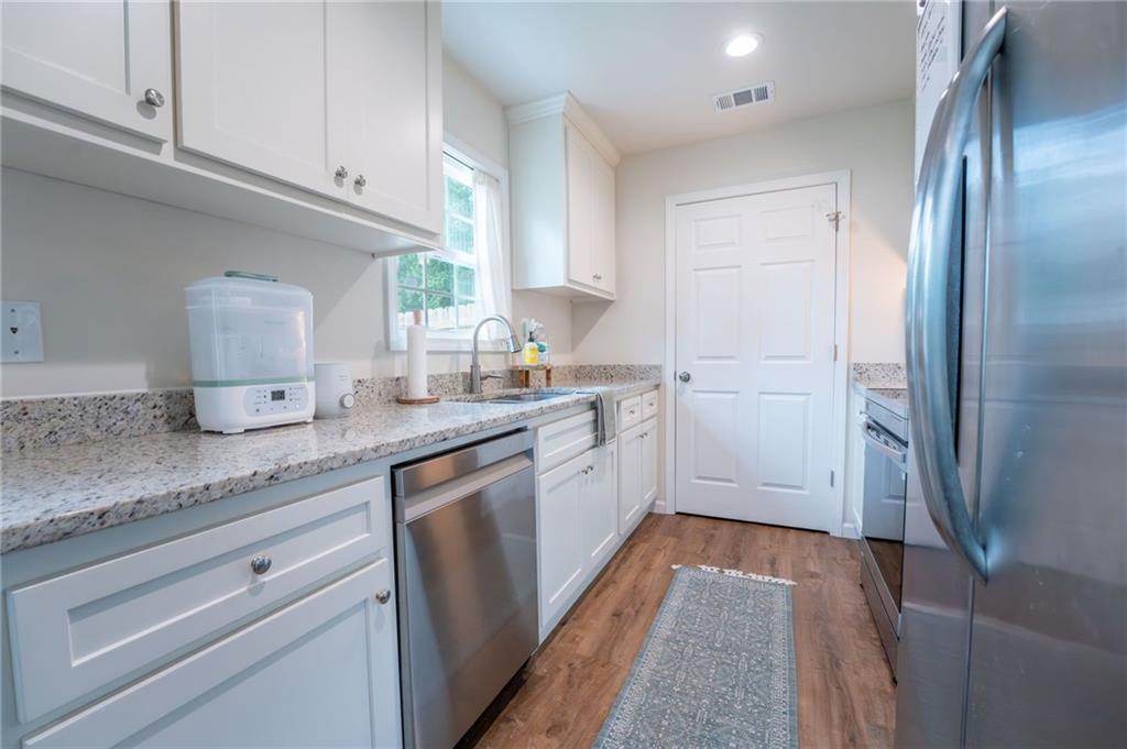 118 Wash Rider Road Dahlonega, GA 30533 - Photo 18 of 37 a kitchen with granite countertop stainless steel appliances a sink stove refrigerator and cabinets