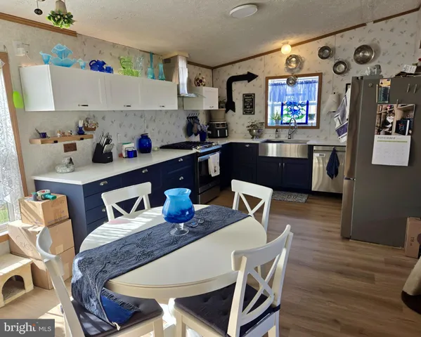 a kitchen with granite countertop lots of wooden furniture cabinets and wooden floor