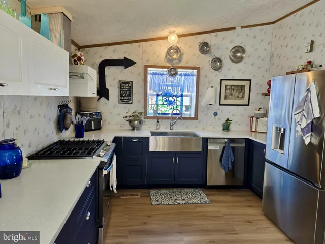 a kitchen with stainless steel appliances granite countertop a refrigerator stove and sink