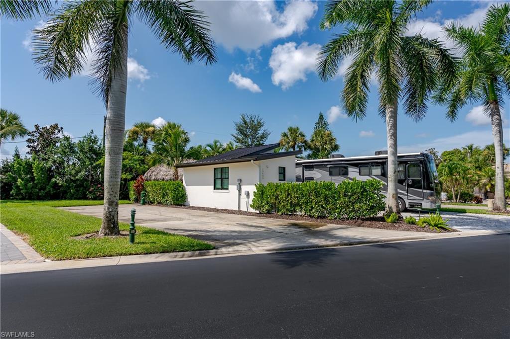 13499 Snook Circle Naples, FL 34114 - Photo 11 of 39 a front view of a house with garden and patio