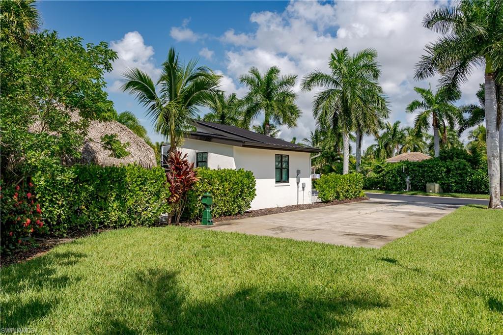 13499 Snook Circle Naples, FL 34114 - Photo 24 of 39 a front view of a house with a yard and a garden