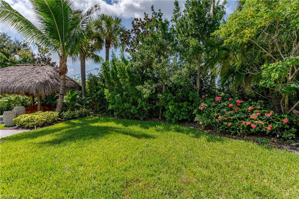 13499 Snook Circle Naples, FL 34114 - Photo 6 of 39 a view of a garden with plants and palm trees