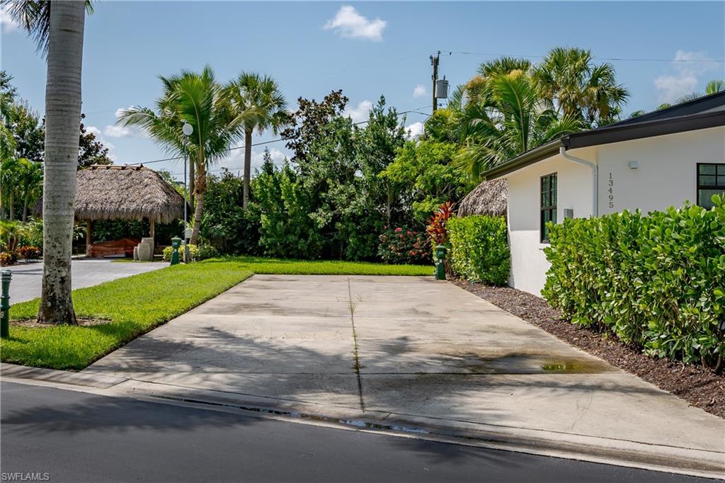 13499 Snook Circle Naples, FL 34114 - Photo 10 of 39 a view of a backyard with a fountain plants and large tree