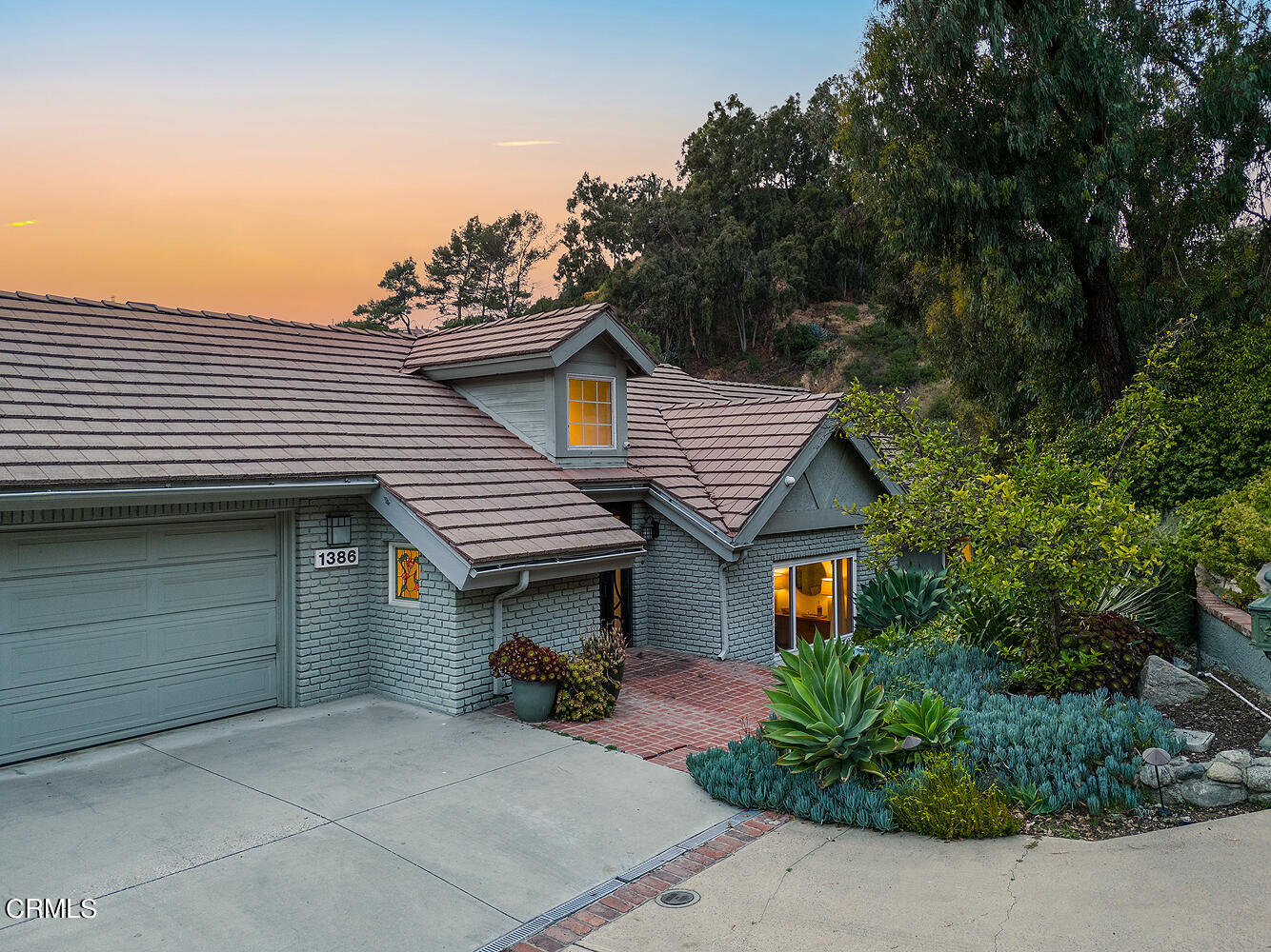 a view of a house with a garage and outdoor seating