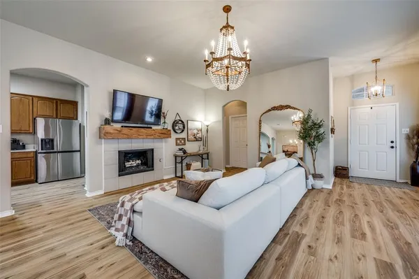 a living room with furniture a fireplace and chandelier