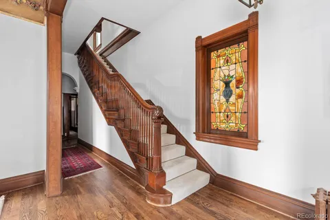 a view of staircase with wooden floor and a front door