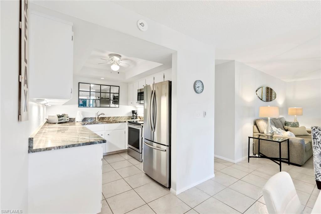 136 Harrison Road, Unit 1 Naples, FL 34112 - Photo 8 of 29 Kitchen area featuring white cabinetry, stone-finish countertops, and stainless steel appliances