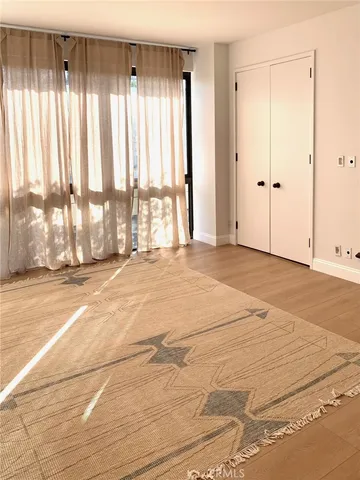 a bedroom with a balcony and large window