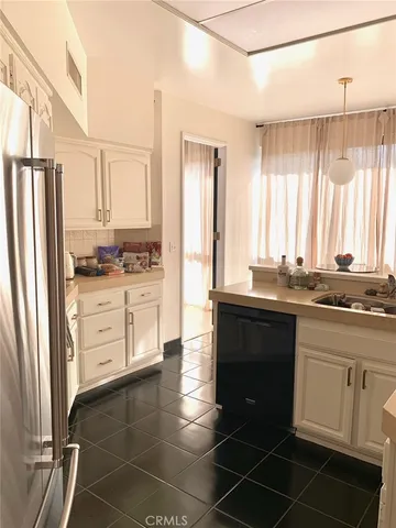 a kitchen with a dining table chairs and white appliances