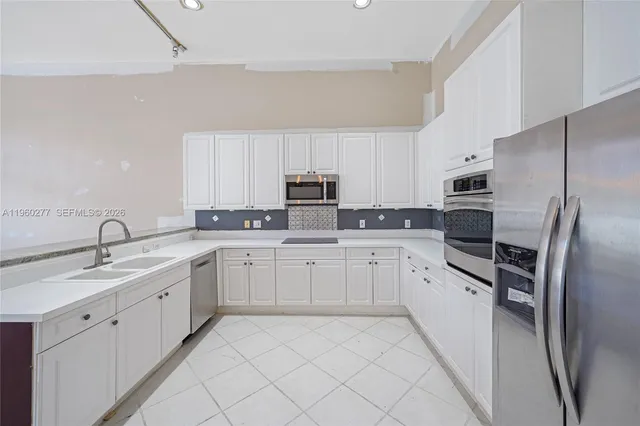 a kitchen with white cabinets sink and stainless steel appliances