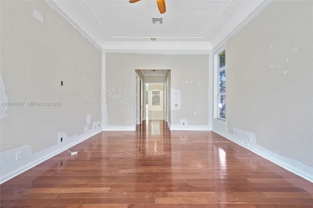 a view of an empty room with wooden floor