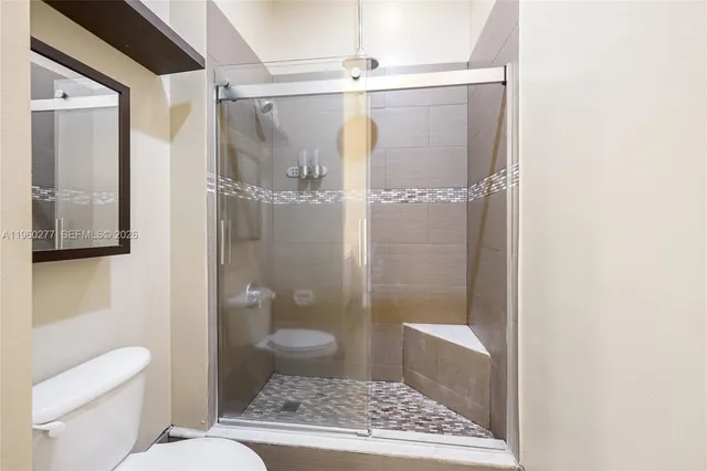 a bathroom with a granite countertop shower a toilet and a sink