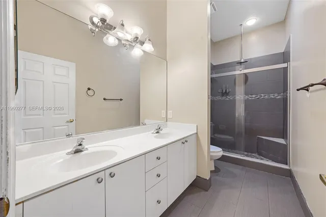 a bathroom with a double vanity sink mirror and shower
