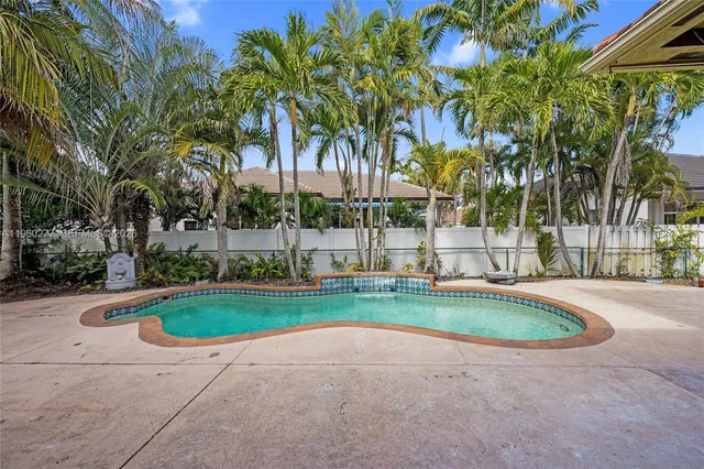 a view of a swimming pool with a garden and trees