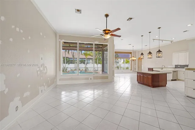 a large white kitchen with a large window and cabinets