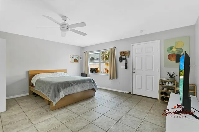 a spacious bedroom with a bed and ceiling fan