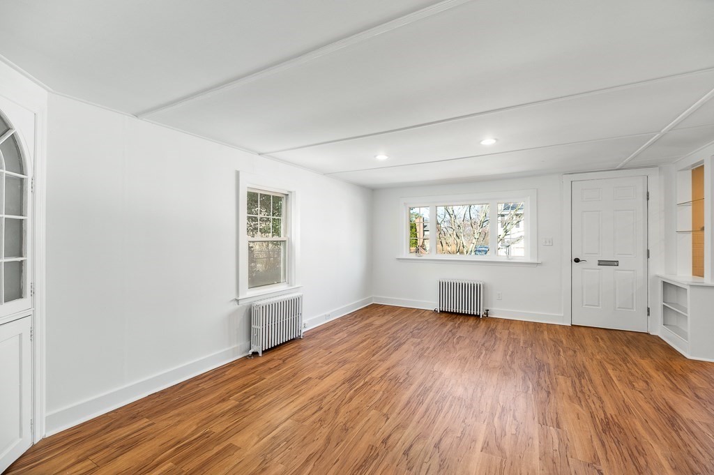 3 Davis St Extension Gloucester, MA 01930 - Photo 7 of 29 an empty room with wooden floor a ceiling fan and windows