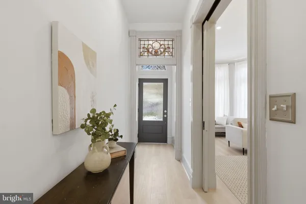 a view of a hallway with wooden floor and a potted plant