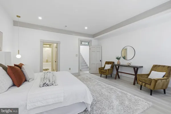 a spacious bedroom with a bed a table and a chandelier