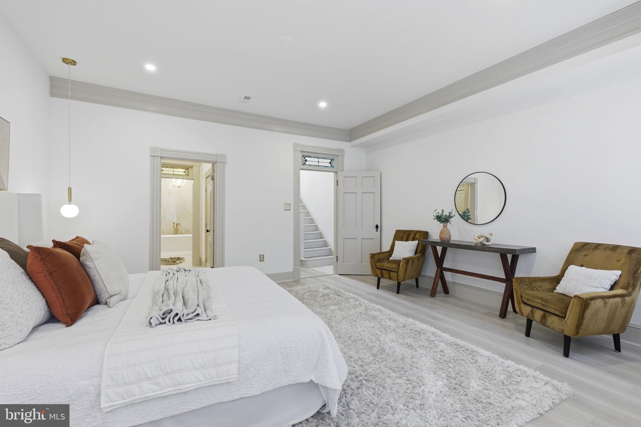 1210 T Street Northwest Washington, DC 20009 - Photo 21 of 41 a spacious bedroom with a bed a table and a chandelier