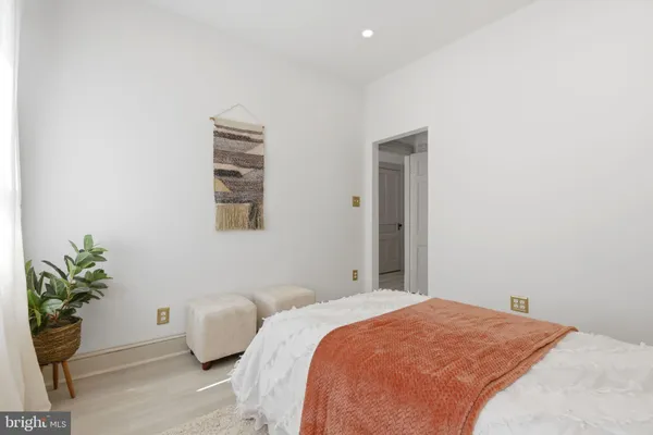 a bedroom with a bed and a potted plant