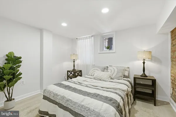 a bedroom with a bed lamp and a potted plant