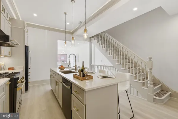 a kitchen with stainless steel appliances granite countertop a sink a stove and a refrigerator