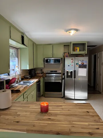 a kitchen with stainless steel appliances a stove a sink and a refrigerator