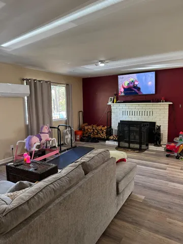 a living room with furniture a fireplace and a flat screen tv