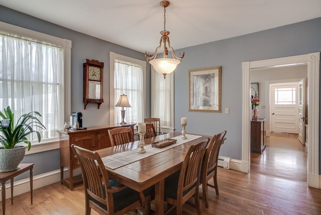349 Boston Road Billerica, MA 01821 - Photo 8 of 41 a dining room with wooden floor a chandelier a wooden table and chairs