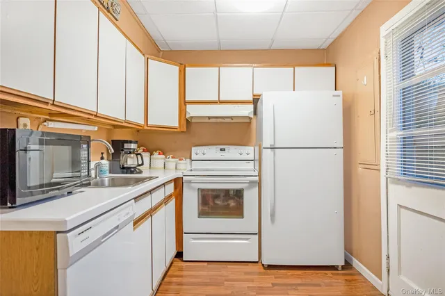 a kitchen with a sink cabinets and wooden floor