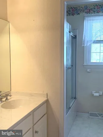 a spacious bathroom with a double vanity sink and a mirror