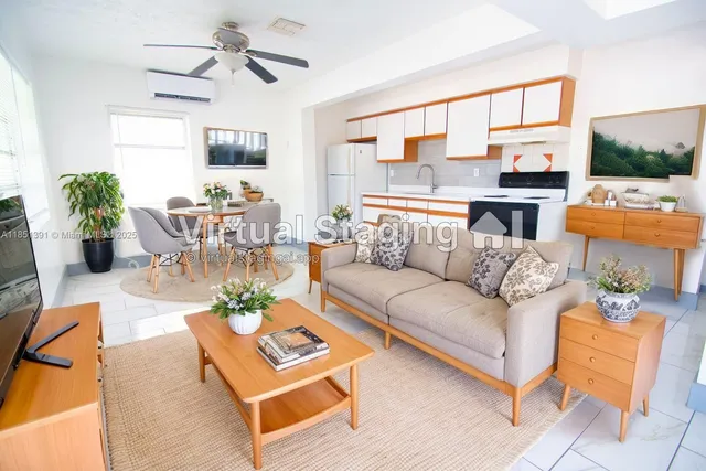 a living room with furniture kitchen view and a large window