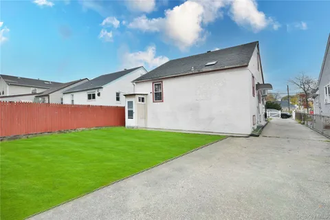 a backyard of a house with lots of green space and outdoor seating