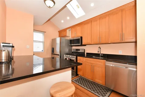 a kitchen with stainless steel appliances a refrigerator sink and microwave