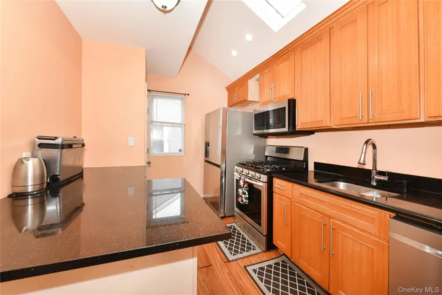 a kitchen with stainless steel appliances a sink a stove top oven a counter space and cabinets