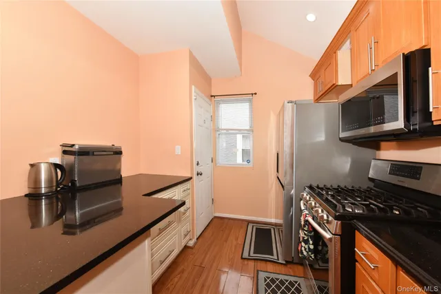 a kitchen with stainless steel appliances a stove and a microwave