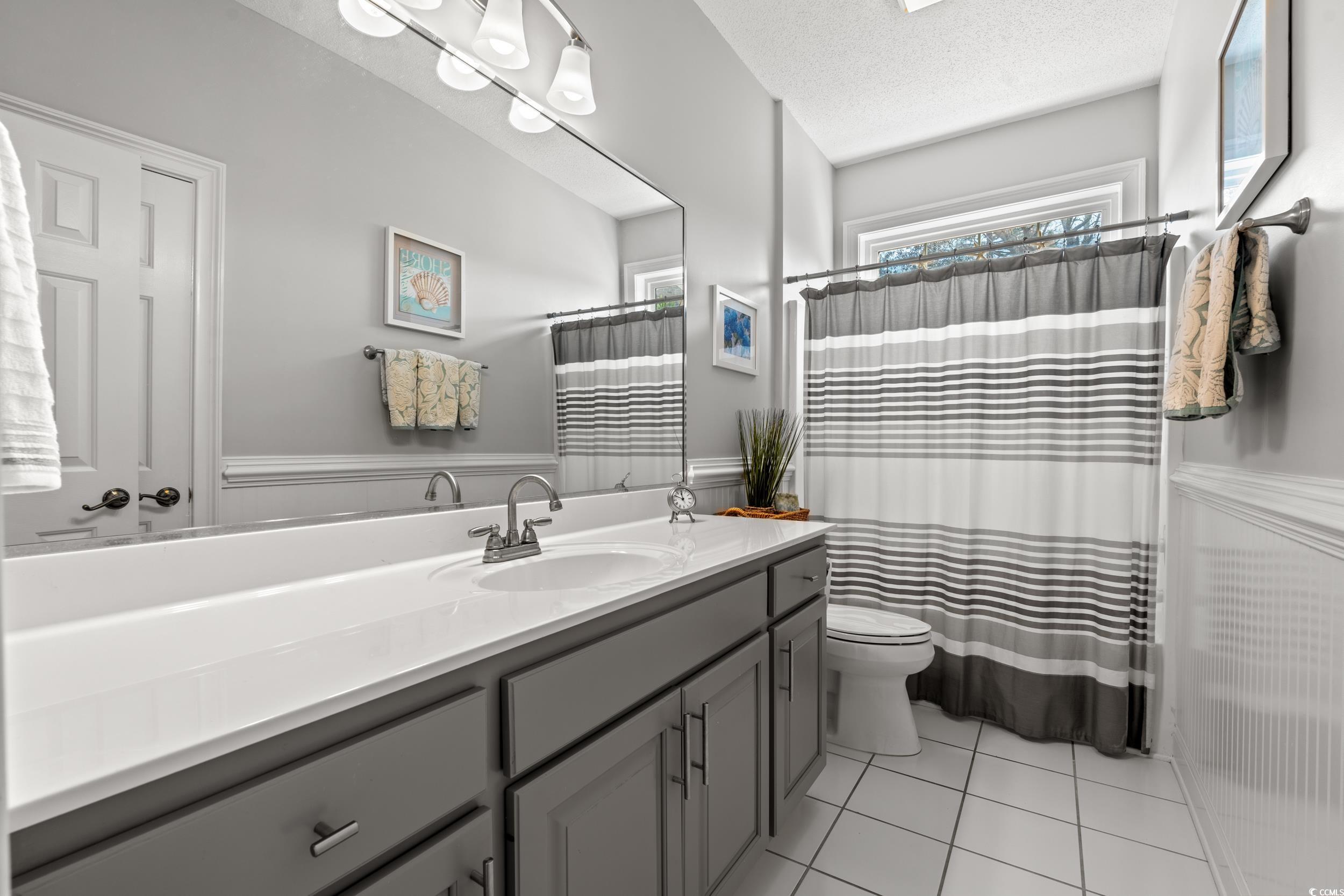 30 Baldwin Loop Pawleys Island, SC 29585 - Photo 29 of 39 Full bathroom featuring toilet, wainscoting, a tex