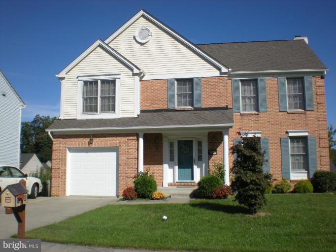 a front view of a house with a garden and plants