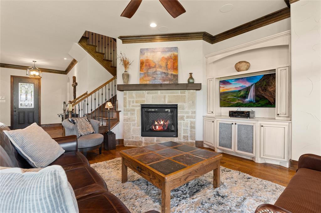 293 Harborview Drive Rockwall, TX 75032 - Photo 17 of 37 a living room with furniture a flat screen tv and a fireplace