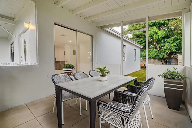 a view of a patio with table and chairs and potted plants