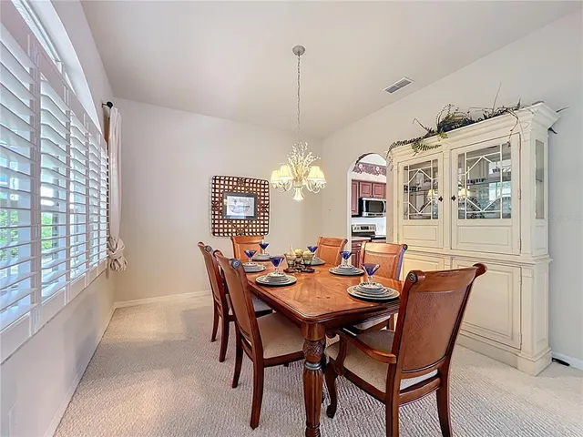 a dining room with furniture a chandelier and window