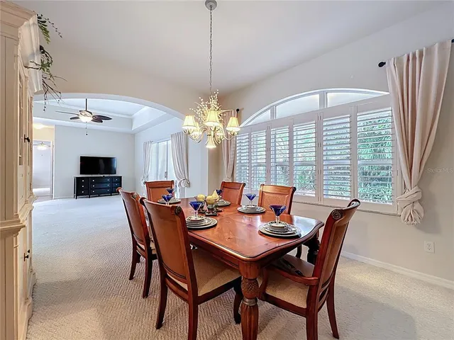a dining room with furniture a chandelier and a rug