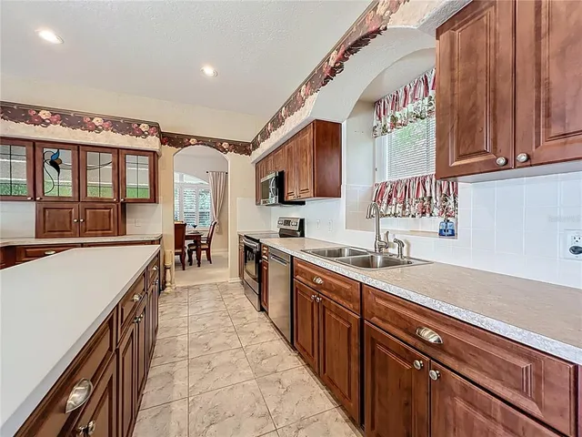 a kitchen with stainless steel appliances sink stove microwave and cabinets