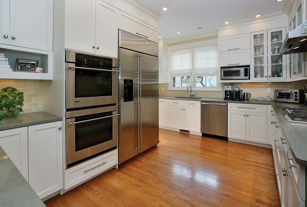 107 Manet Road Newton, MA 02467 - Photo 3 of 10 a kitchen with stainless steel appliances kitchen island granite countertop a stove top oven a sink and white cabinets