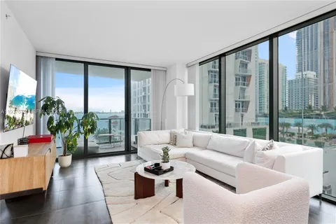 a living room with furniture and a floor to ceiling window